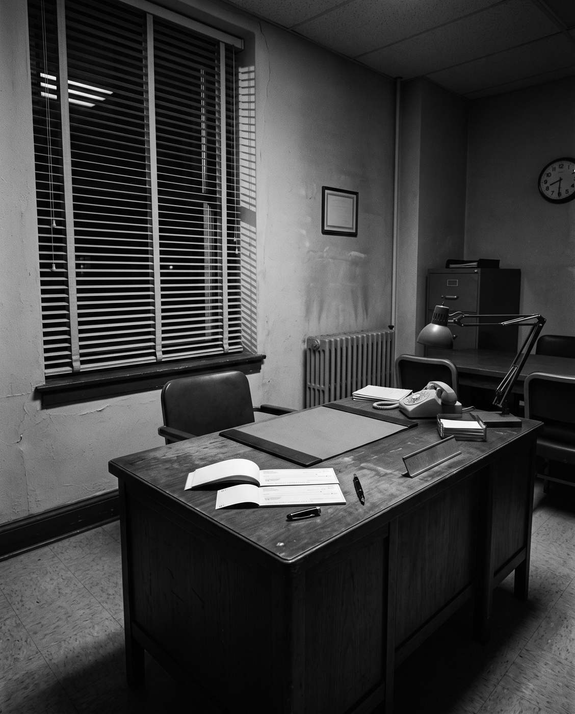An empty office after hours, an open cheque book on the desk